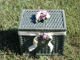 Green rectangle basket with white and purple flowers on top.