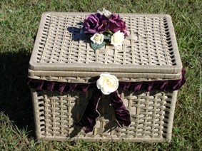 Tan colored basket with burgundy flowers on top.